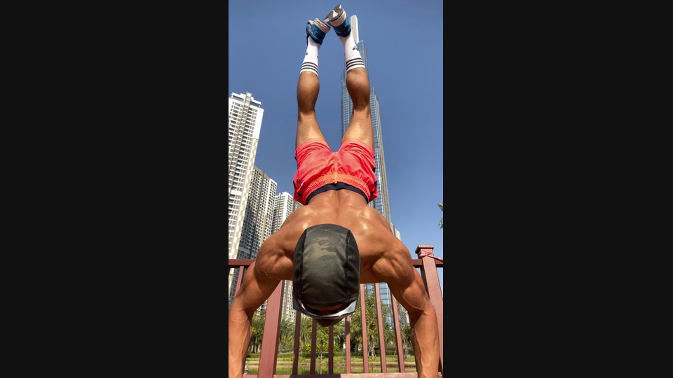 An inverted outdoor training movement photographed from a close, low angle.